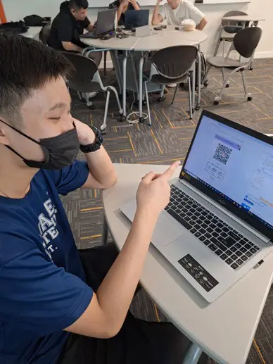 One student pointing the nets qr